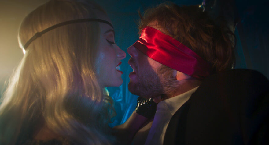 A seductive woman teases a blindfolded young man