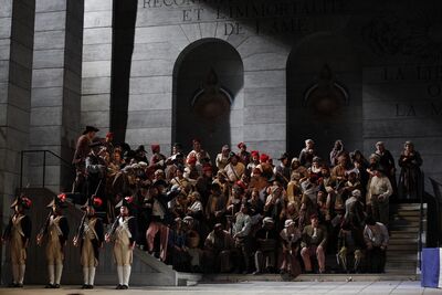 A crowd of singers on stage in a scene from Andrea Chenier
