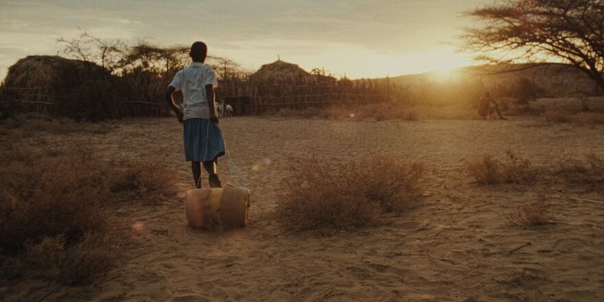 a girl looks out at the horizon in rural Kenya