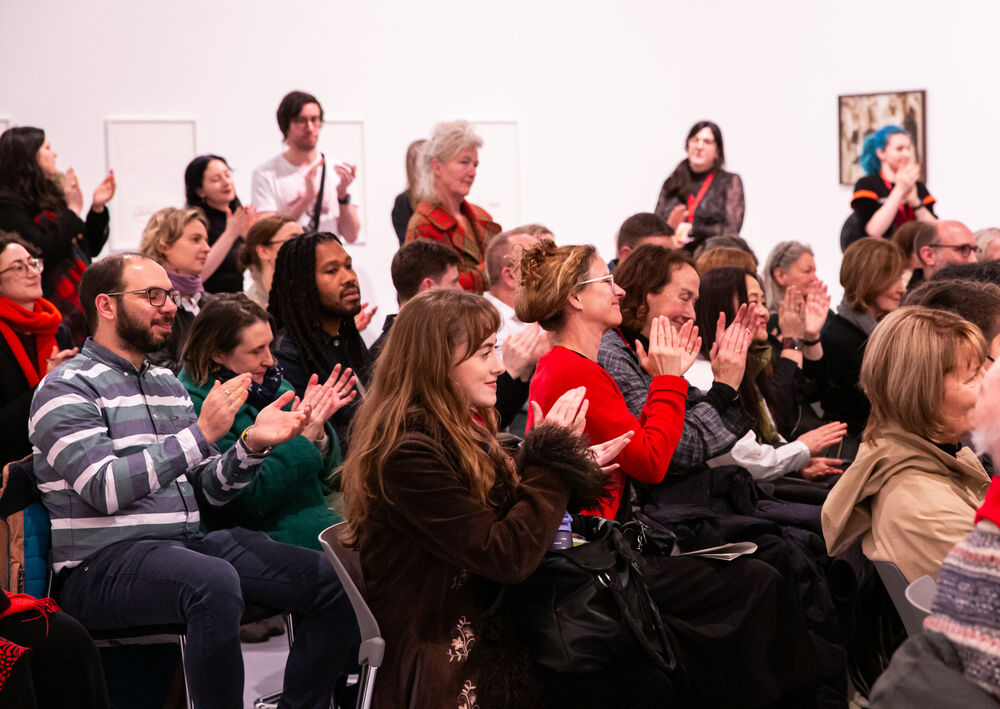 An audience of people clap