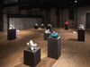 An exhibition space with small sculptures on plinths 