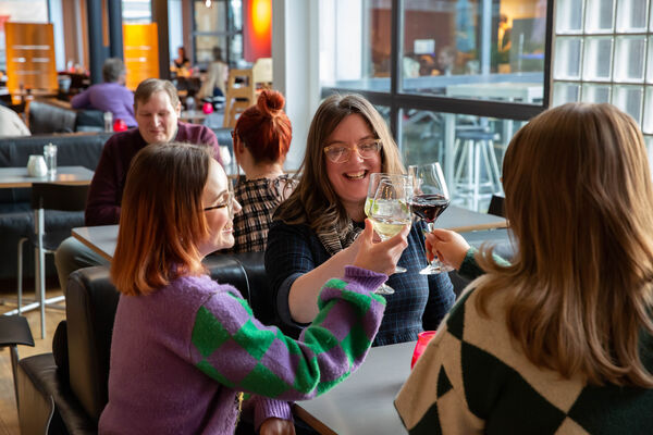 Three people holding up their wine glasses in Jute Cafe Bar