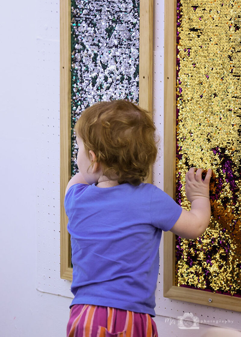 Child playing with sequin fabric