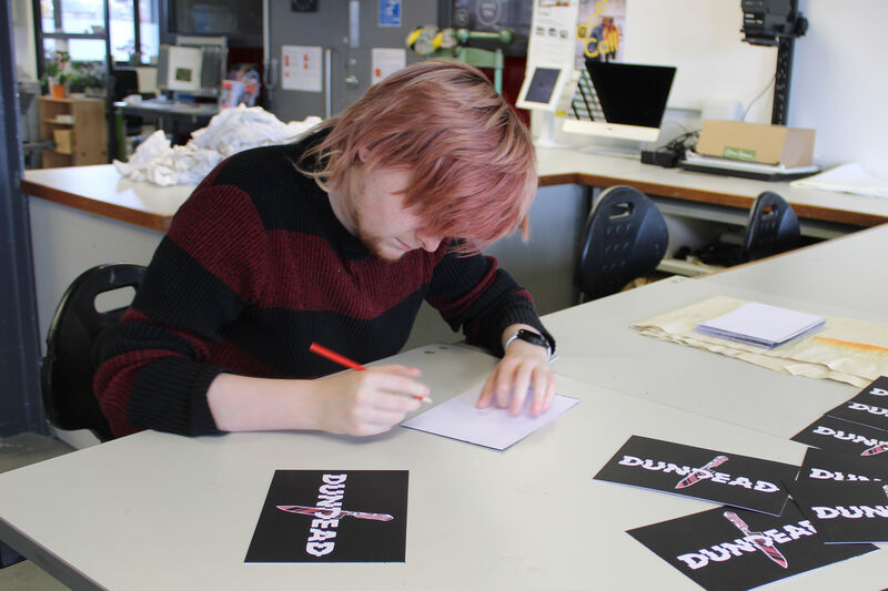Liam Doyle signing Dundead prints in DCA Print Studio