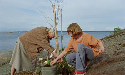 A girl and her grandmother gardening by the coast