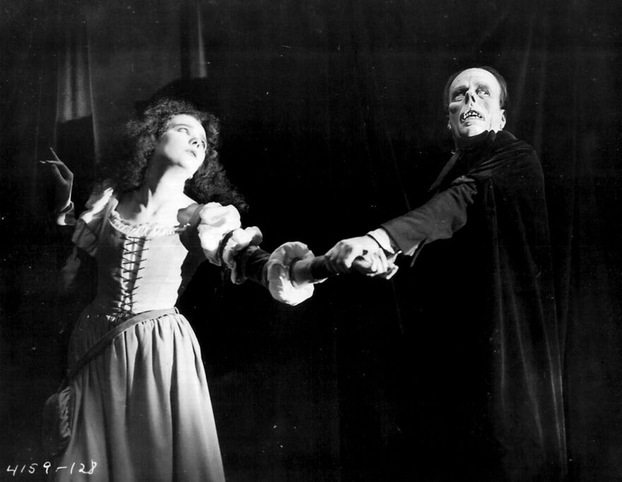 Woman and man holding hands against a dark background