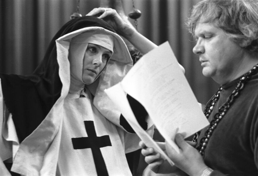 Black and white image of Ken Russell reading a script and actress dressed as a nun