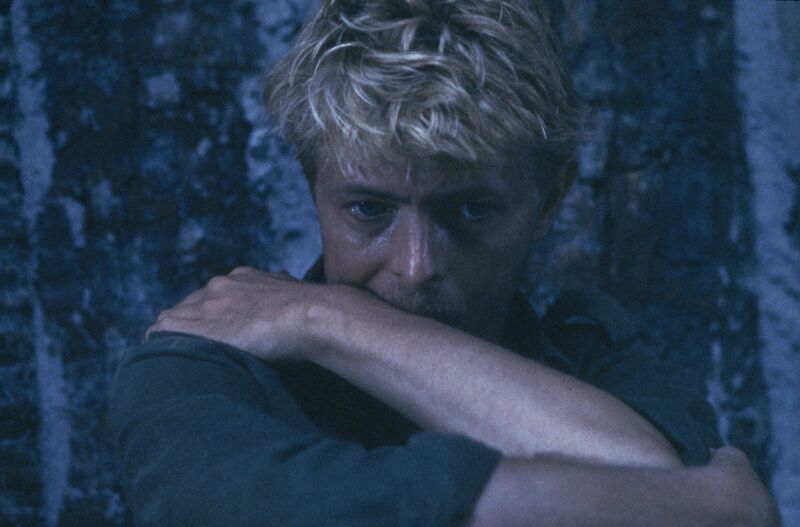 David Bowie sits with his arm across his mouth