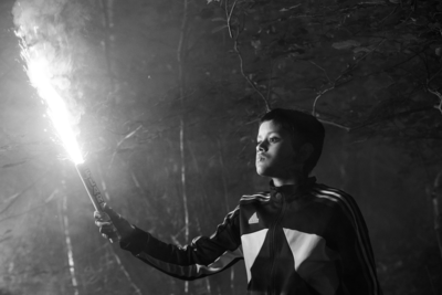 A boy holds a burning flare