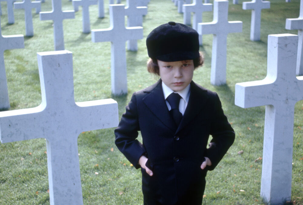 Child standing in a graveyard