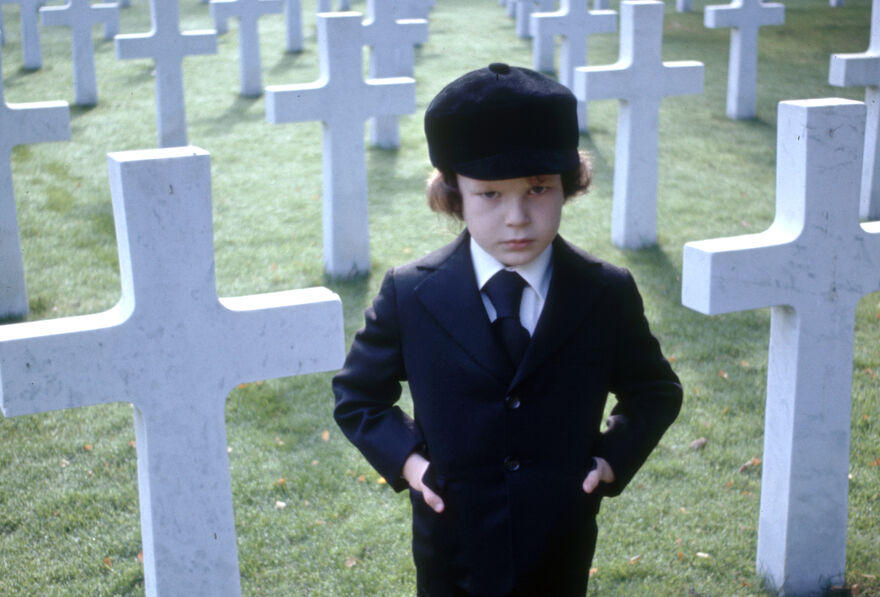 Child standing in a graveyard