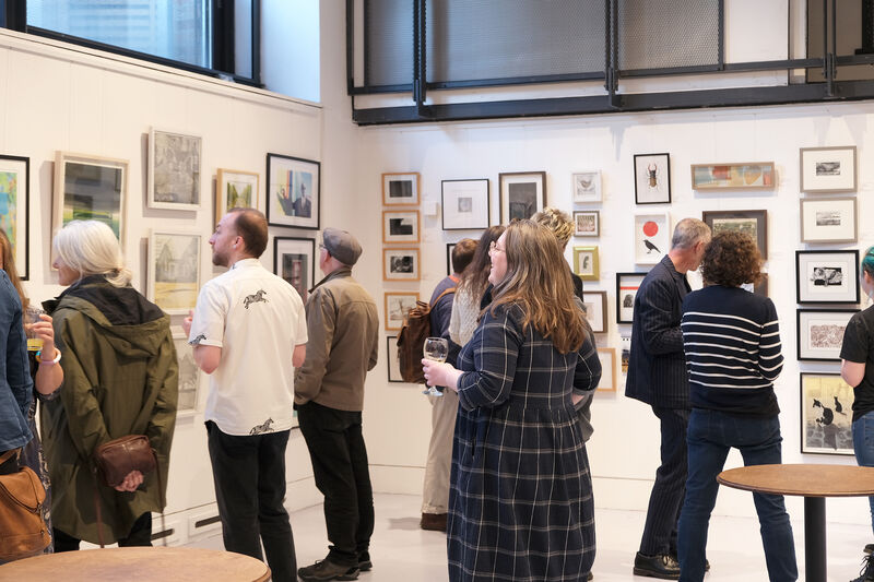 Groups of people in DCA Centrespace looking at framed prints
