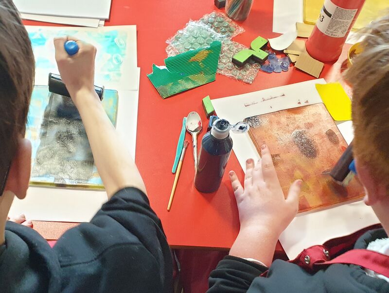 Pupils rolling ink onto a gelli plate