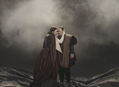 A man and woman embrace on stage in Macbeth