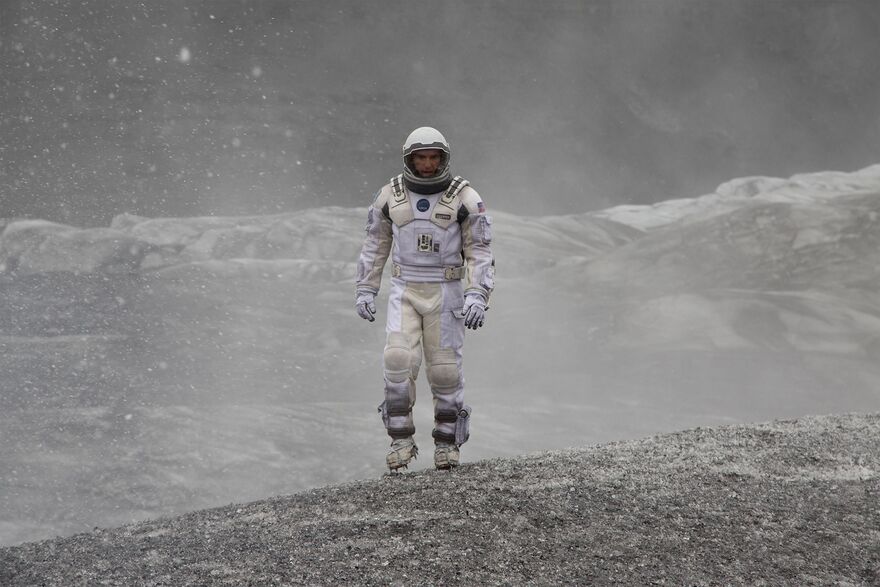 An astronaut walks on a volcanic planet