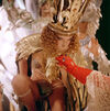 Woman in a grown with red gloved hand reaching for her