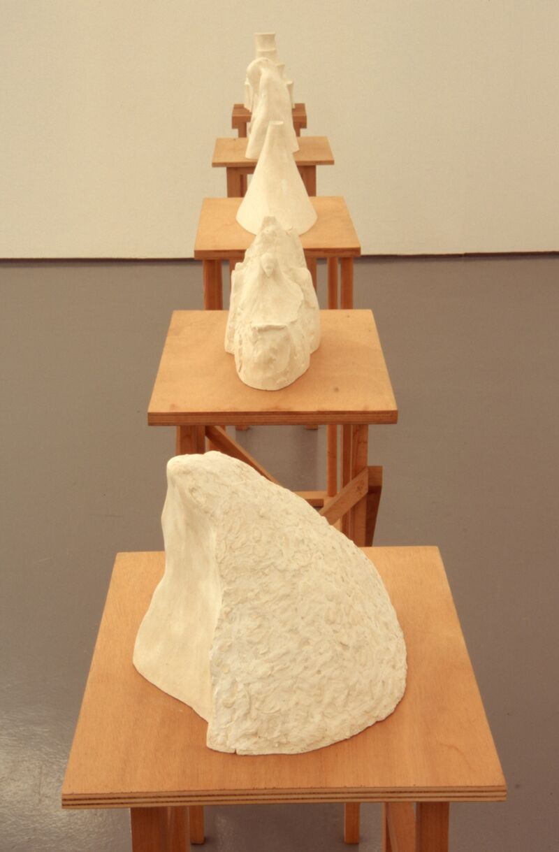 Polished white stones sit on small brown wooden tables.