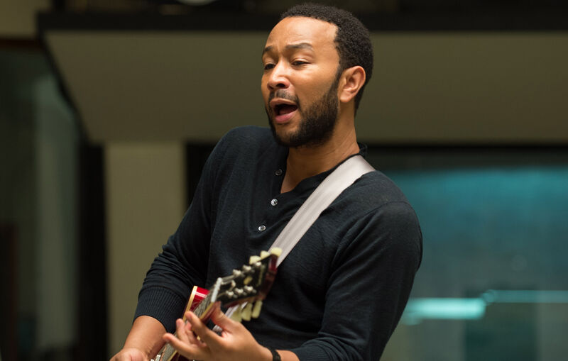 A man sings while playing guitar