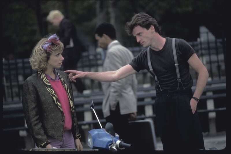A man points at a woman wearing bright eighties fashion.