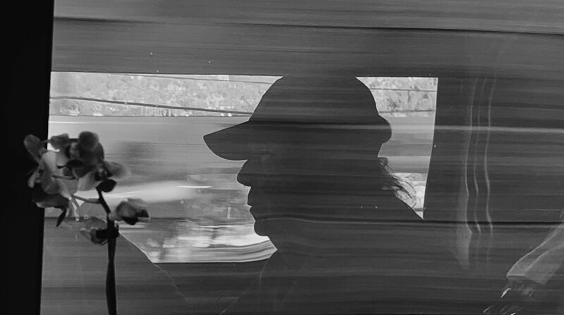 Neil Young wears a base ball cap and is seen in profile.