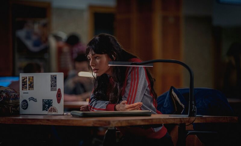 Woman sitting at a desk looking at a laptop