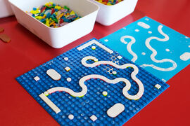 Lego dots arranged on a board and inked up with white ink