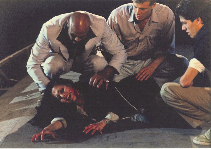 People attending to someon on the ground covered in blood