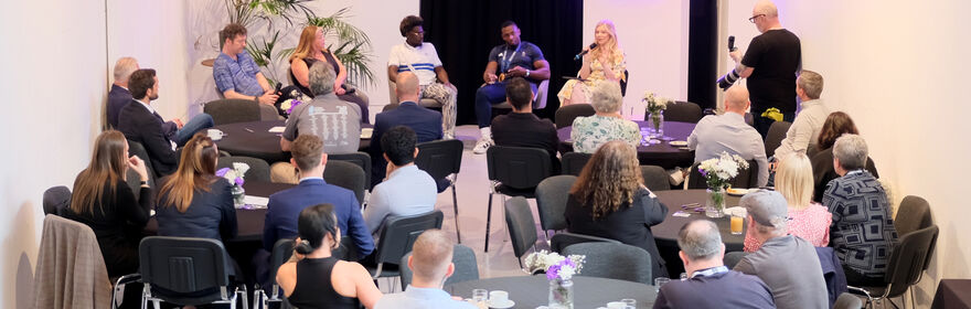 People seated around tables for an event in Centrespace
