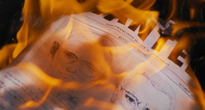 A sheet of paper with drawings of the zodiac killer on them burn.