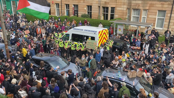 A group of people take part in a protest on Kenmure Street in Glasgow