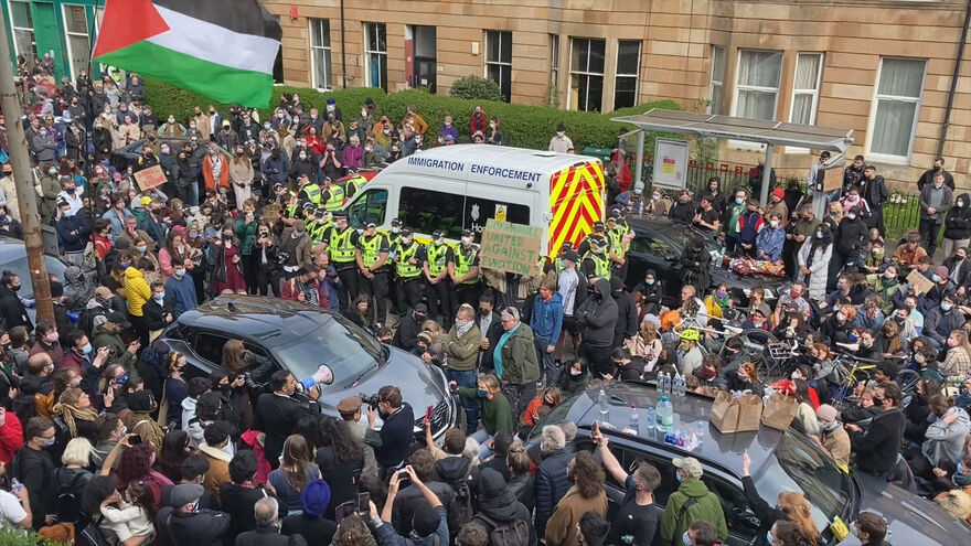 A group of people take part in a protest on Kenmure Street in Glasgow