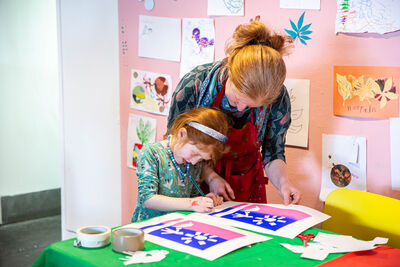 Child and adult signing prints at Family Art Lab