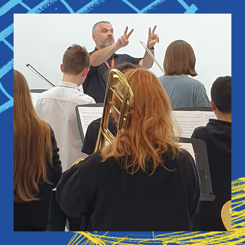 Person conducting pupils playing instuments in DCA Galleries