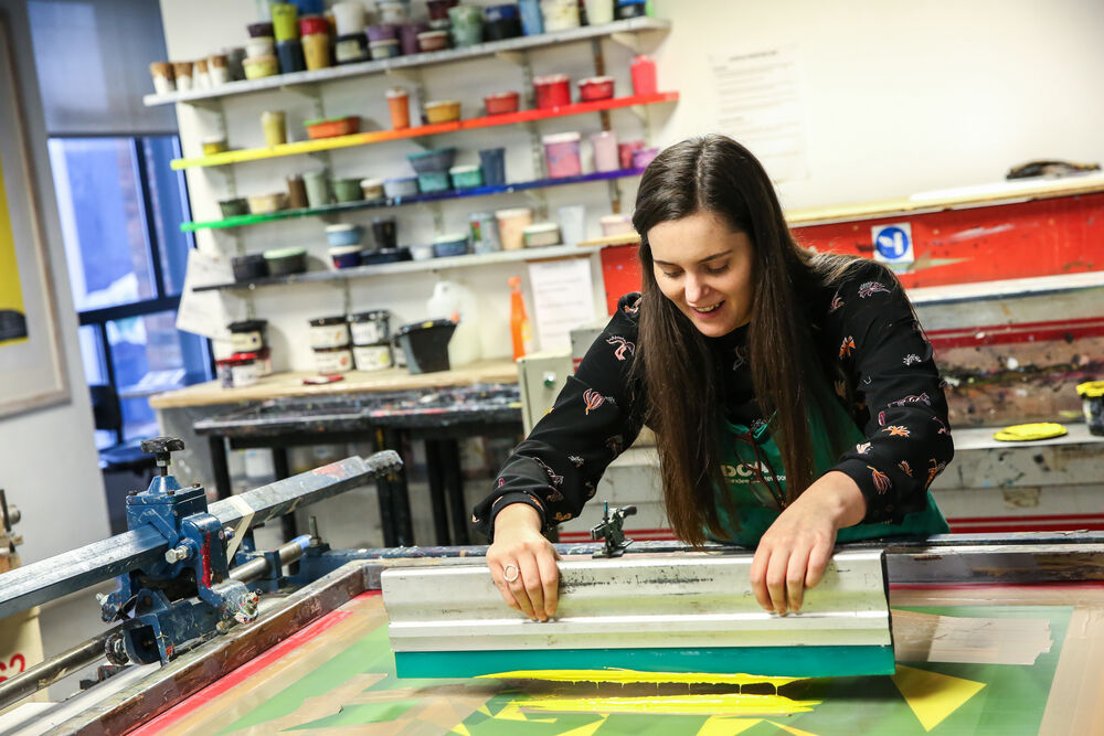 Person screen printing on a power-assited screen printing table