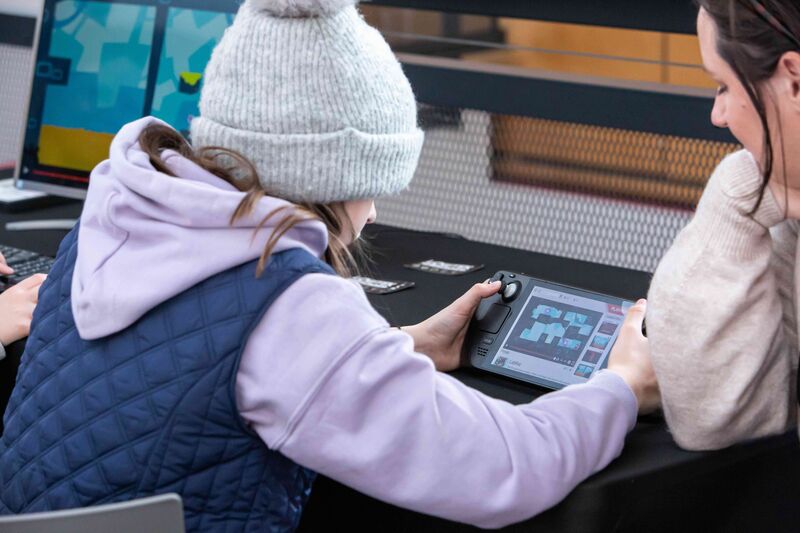 A child plays a console game at Drop in and Play