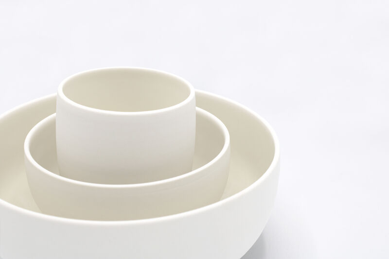 Stack of three white porcelain bowls against a white background