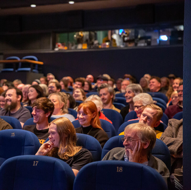 Happy people sitting in cinema seats.