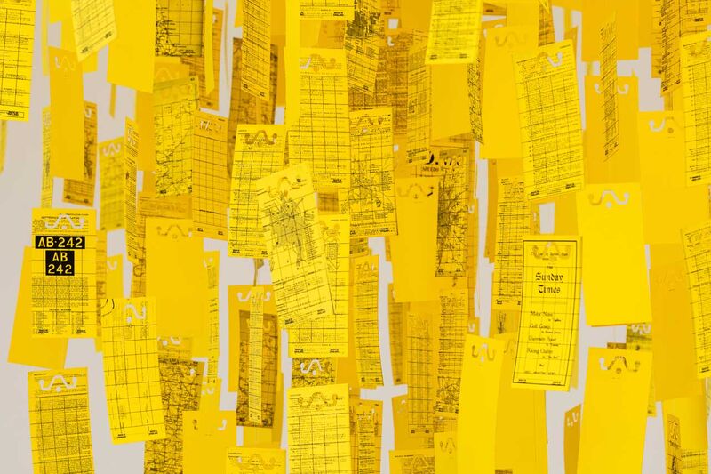 Detail of a hanging sculpture, pages of the Michelin guide to Britain on yellow pages