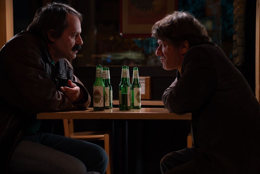Two men at a table with beer bottles