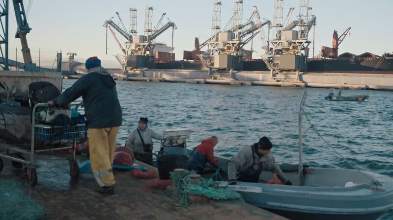 Men on fishing boats at a docks.