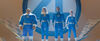 Three people and one man made out of rocks stand behind a giant number 4, all wearing blue suits with the number 4 on them.
