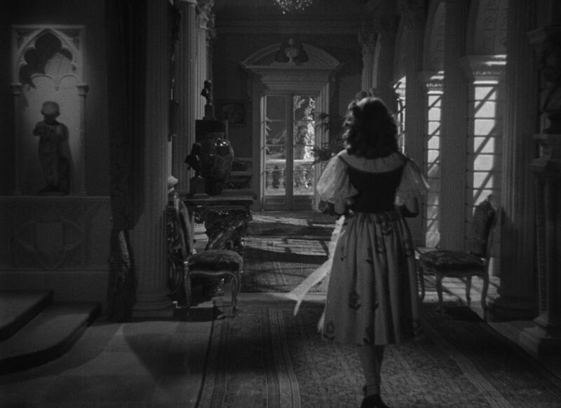Woman walking down an ornate corridor