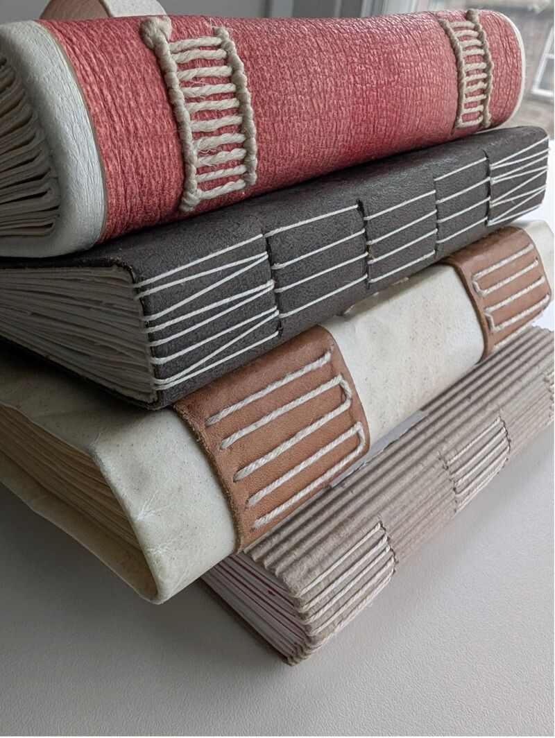 Stack of hand made books with different stitch patterns on the spines