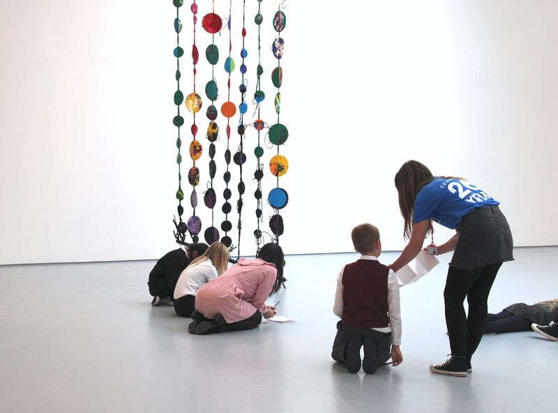 Children sit on the floor and draw in DCA Gallery. 