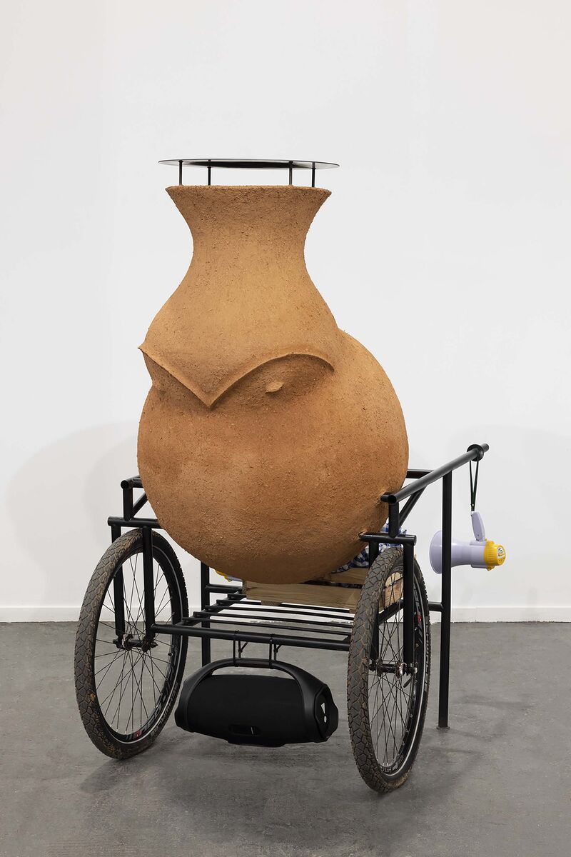 a clay oven with shaped like a bird on wheels
