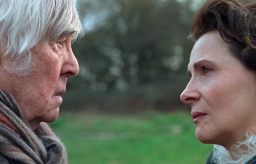 An old man and a woman look into each other's eyes