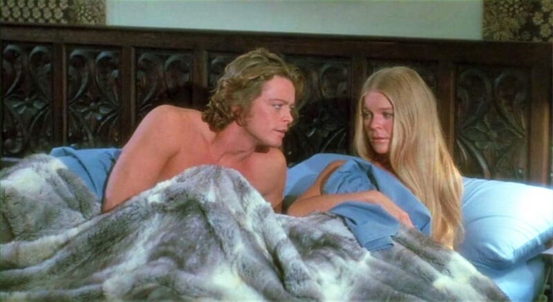 A man and a woman talk in bed