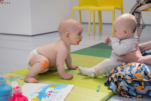 Two babies play with paint at Messy Play.