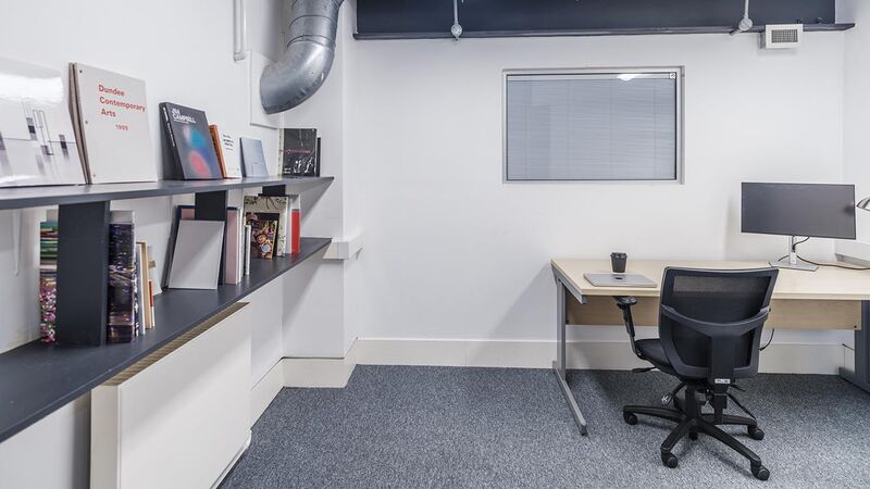 A small office space with shelves and books on the wall