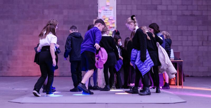 Group of school children walking on Biome Collective's light up floor
